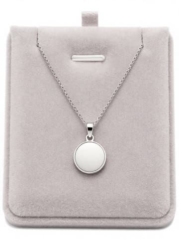 Silver round pendant necklace on a gray suede jewelry display board