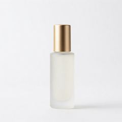 Minimal style: frosted glass bottle with a gold cap against a pure white background